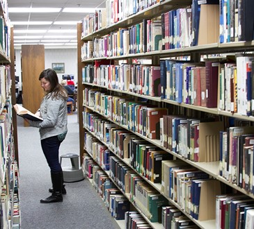 library student looking at book