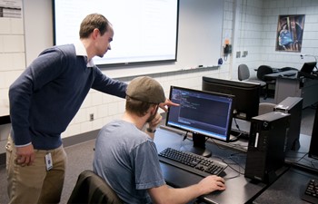 Teacher helping student at computer