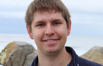 Student near rocks on beach