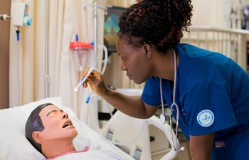 Nursing student examining patient.