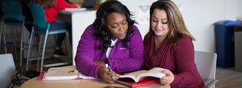 Two students studying together at a table.