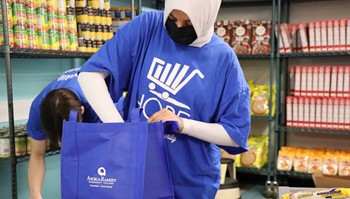 Student employees prepare food bags before food pantry opening.