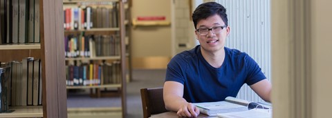 Student in library looking directly at camera