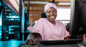 student in pink shirt in computer lab classroom