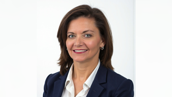 Portrait of a professionally dressed individual with short hair, smiling at the camera against a plain white background.